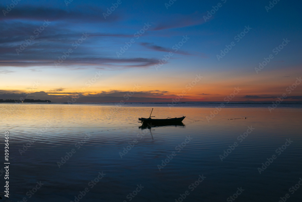 Sunset with fisher boat and still water on Gili Air Island, Indo
