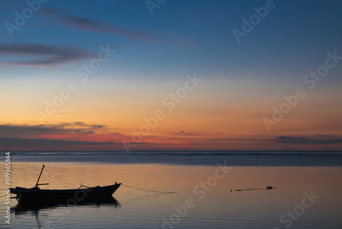 Sunset with fisher boat and still water on Gili Air Island, Indo