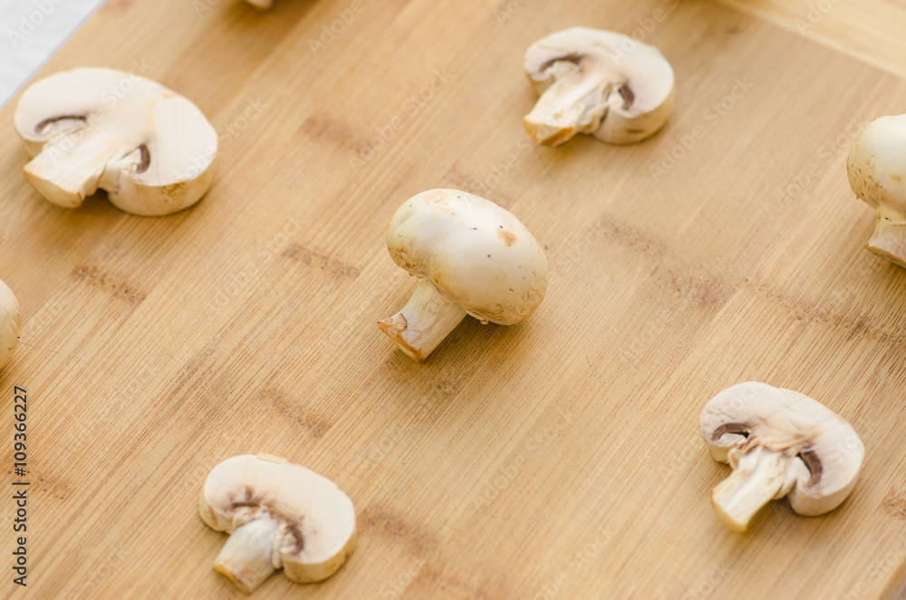 Mushrooms and Food theme: man preparing porcini mushrooms on a wooden board on a background of green grass in summer