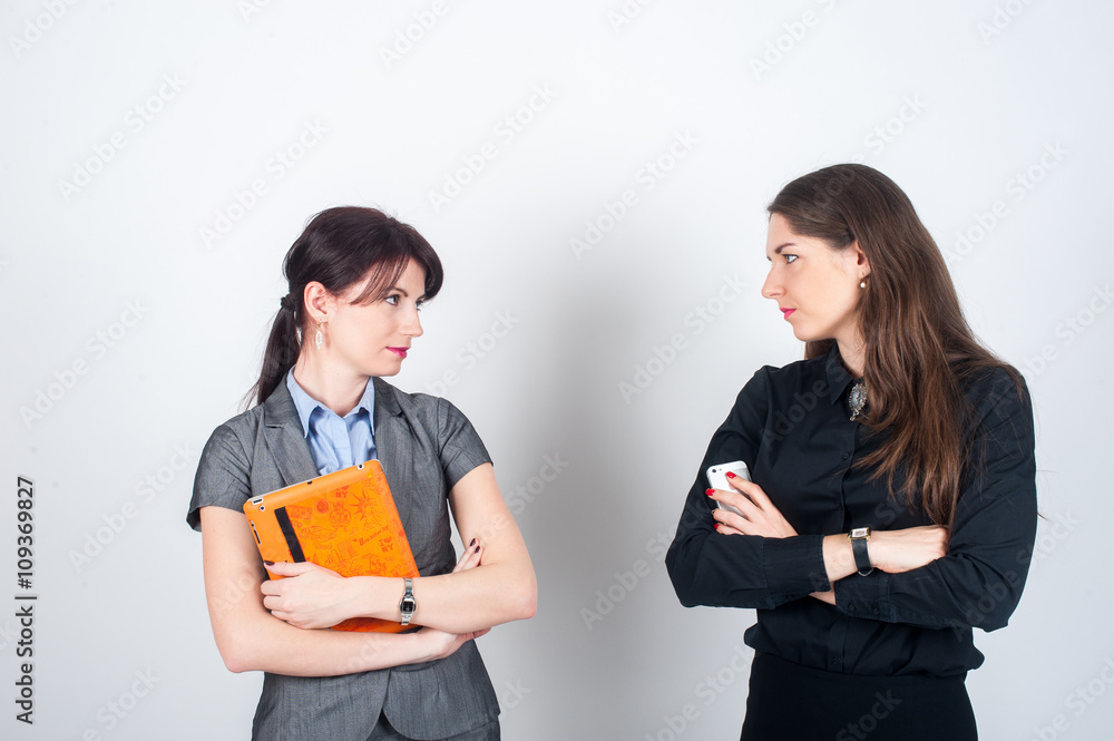 Two business women standing on a light background Two business women standing on a light background
