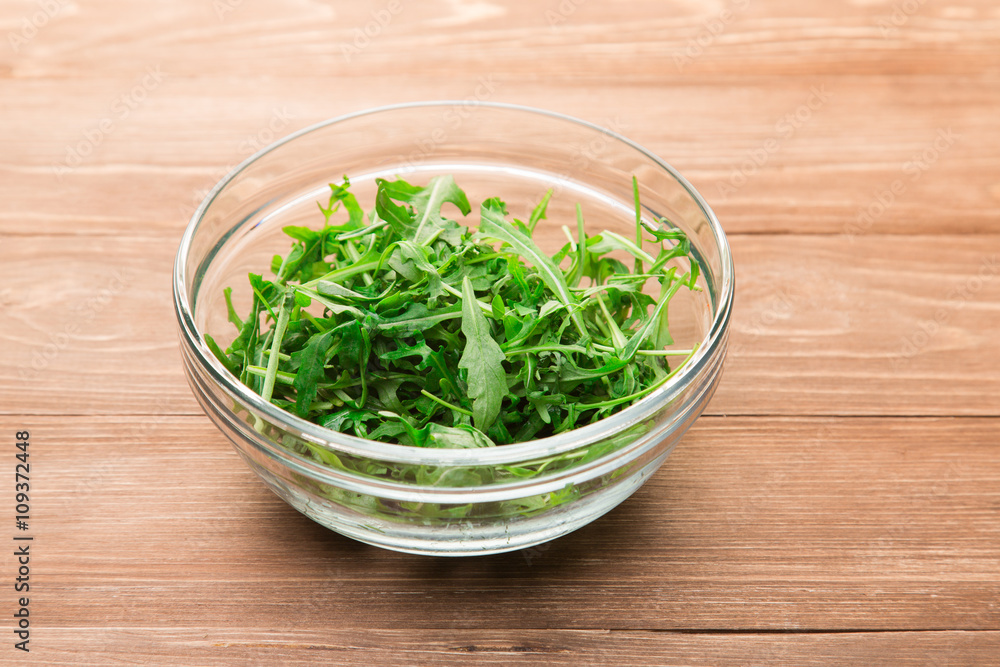 Fresh green arugula leaves in a glass bowl Fresh green arugula leaves in a glass bowl