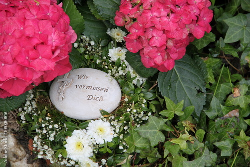 Trauer - Wir vermissen Dich - Stein mit Inschrift und Blumen photo