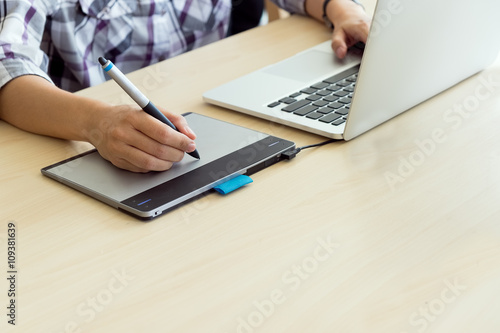 graphic designers hand using pen tablet with stylus and working laptop. with copy space