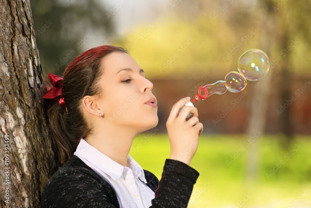 Young girl in a park making soap bubbles Young girl in a park making soap bubbles
