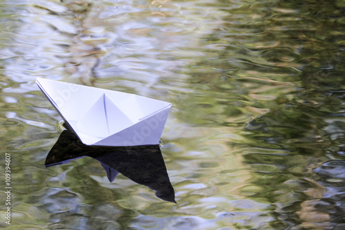 Papierschiff schwimmt im Bach photo