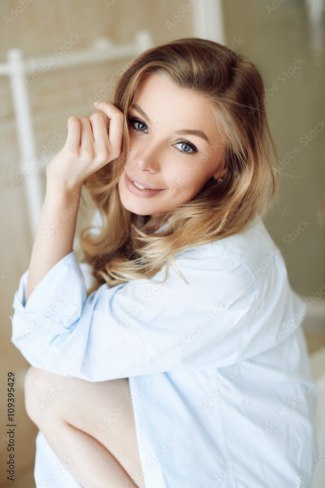 Beautiful young sexy girl in a shirt smiling and looking at the camera Beautiful young sexy girl in a shirt smiling and looking at the camera