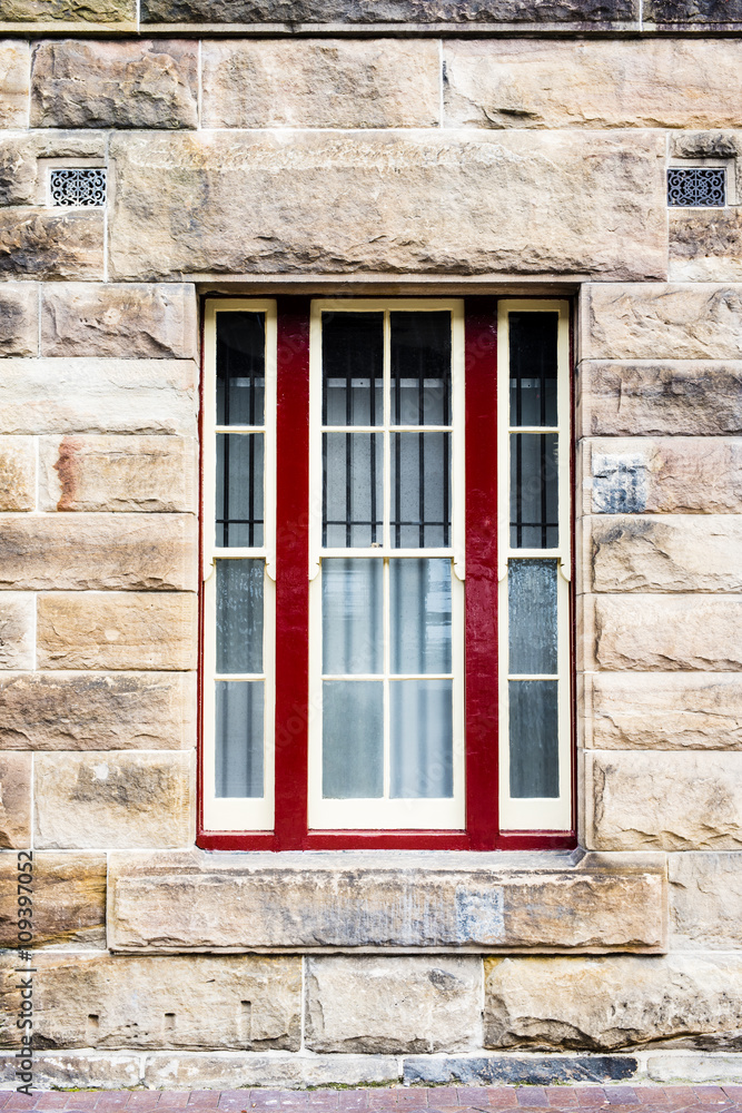 Sandstone wall with red framed window