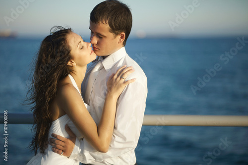 Gorgeous wedding couple kissing on pier under spray, splashes an © Dmitry Yakunin