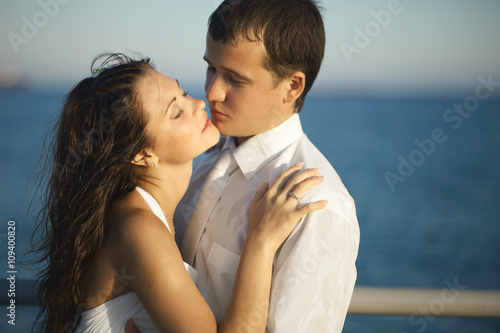 Gorgeous wedding couple kissing on pier under spray, splashes an © Dmitry Yakunin