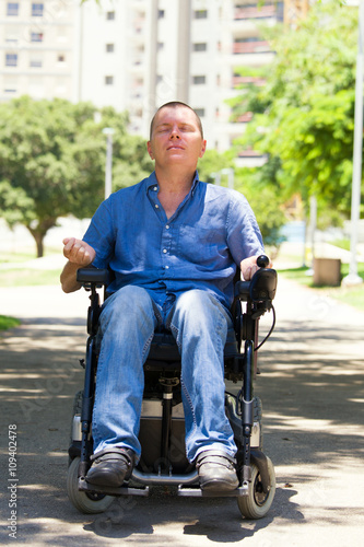 Man in wheelchair practicing meditation at the park