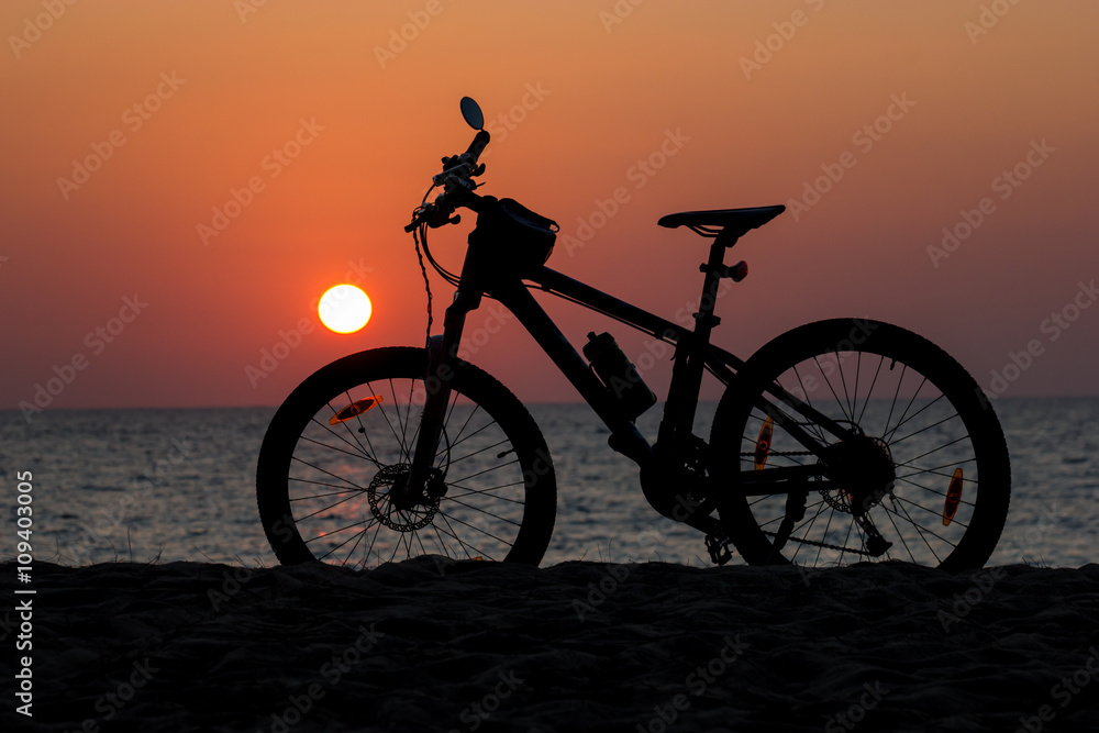 Obraz premium Mountain bike on the beach and sunset
