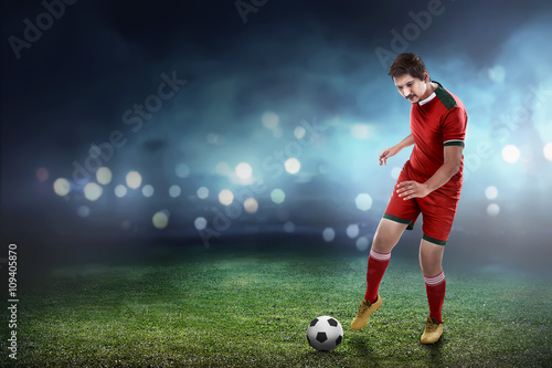 Asian football player kick ball © Leo Lintang