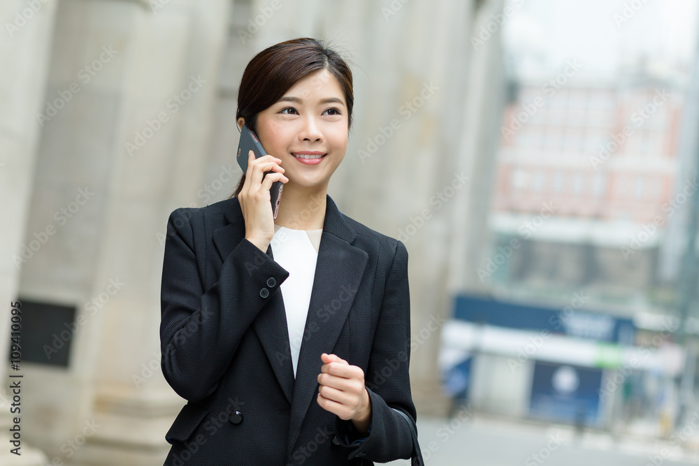 Business woman walking and calling by cell phone Business woman walking and calling by cell phone