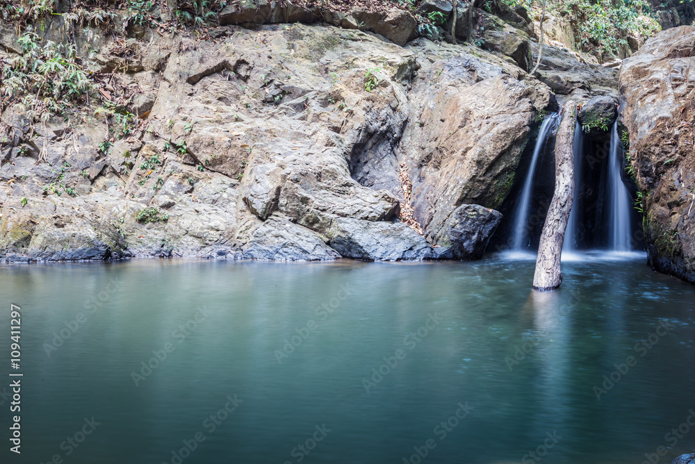 Naklejka premium Stoned waterfall. A narrow water flow between the stones in the forest,Raman waterfall - Phang Nga Province ,Thailand