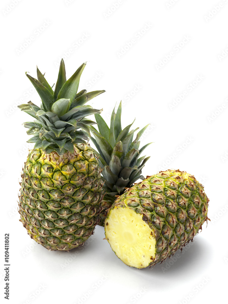two pineapples on white showing one cut two pineapples on white showing one cut