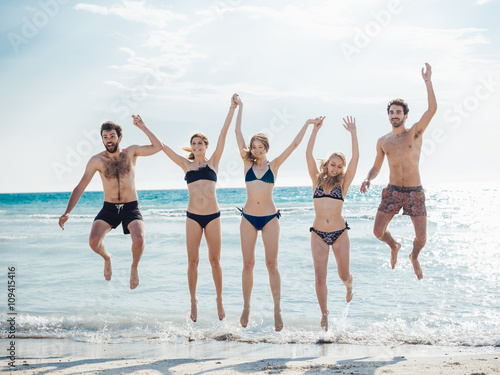 group of people jumping at beach