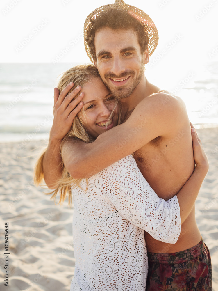 Young couple in love on a white beach at sunset Young couple in love on a white beach at sunset