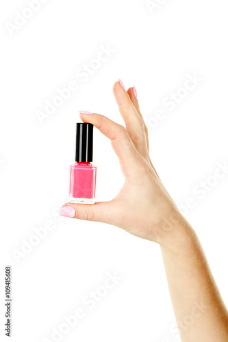 Female hand with manicure holding nail polish on a white backgro