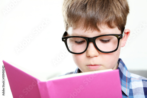 Young boy reading book on a white background