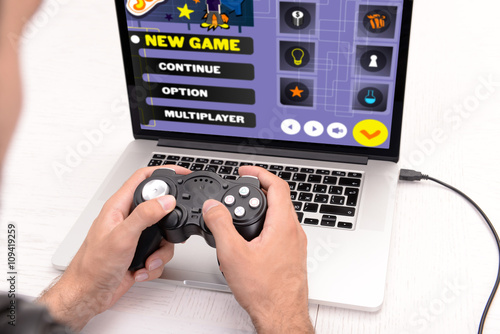 Young man playing computer ...