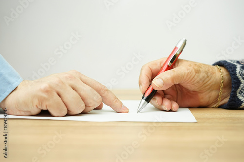 businessman man is pointing senior where to sign contract