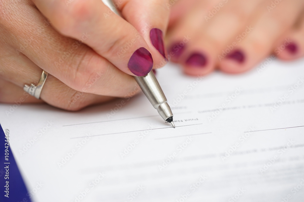 closeup of female hand signing document