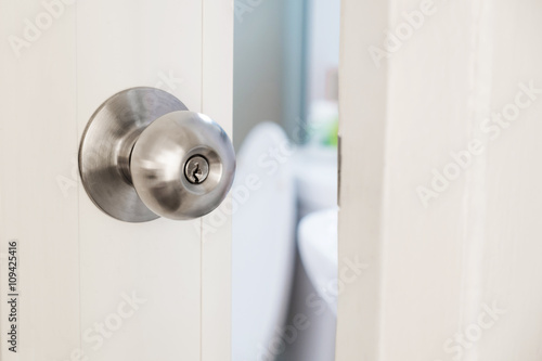 Close-up stainless door knob, with door open slightly photo