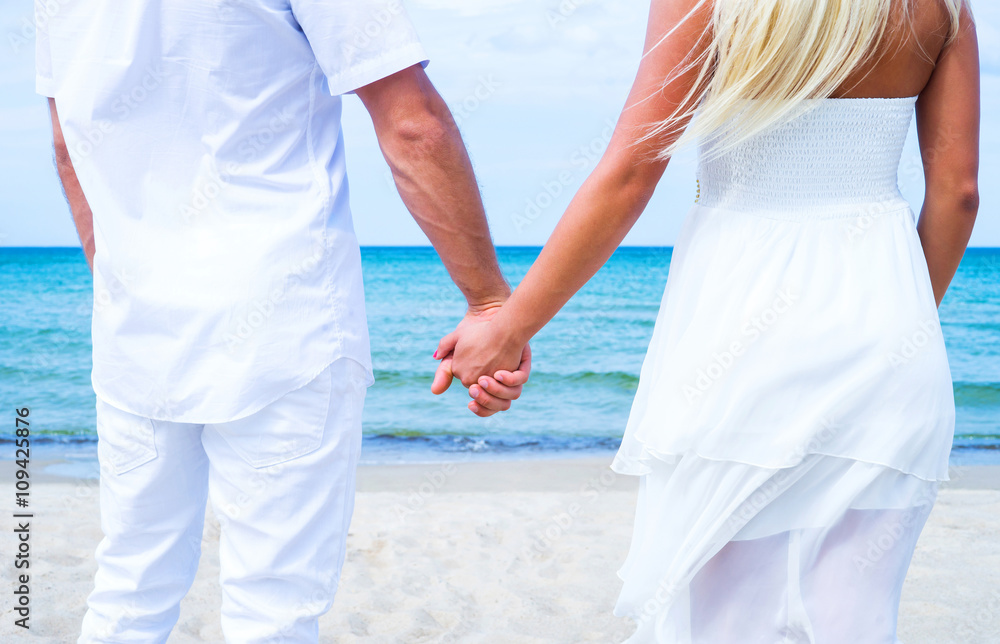 Loving couple walking and embracing on the beach Loving couple walking and embracing on the beach
