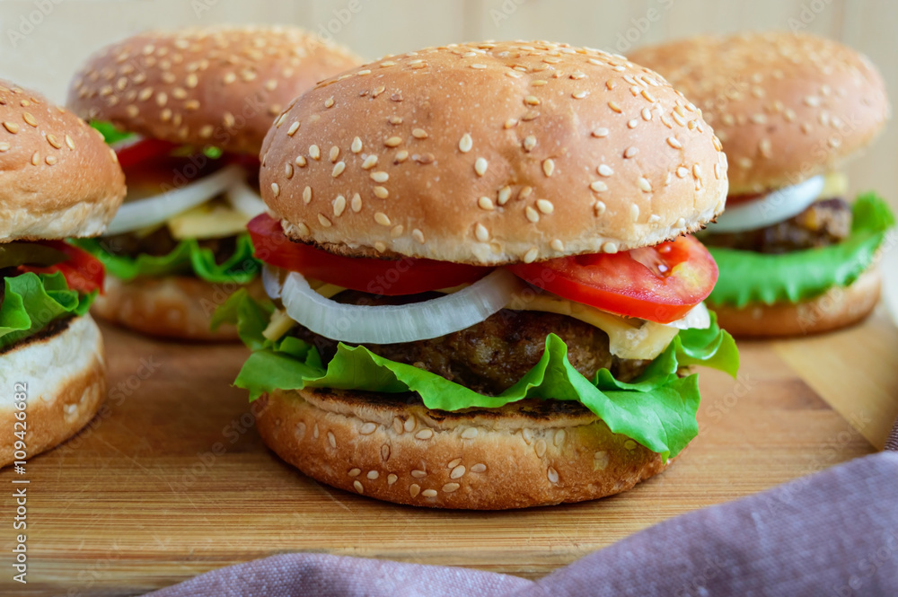 Sandwich homemade hamburger with juicy burgers, cheese, fresh vegetables Sandwich homemade hamburger with juicy burgers, cheese, fresh vegetables