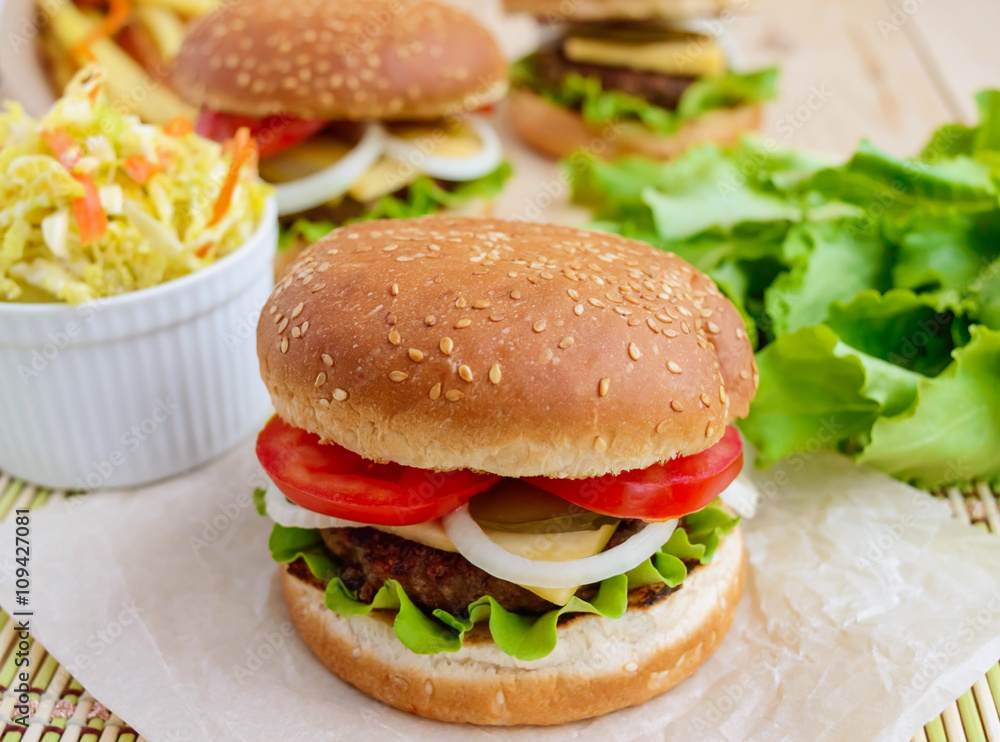 Sandwich home of the hamburger buns soft, juicy burger, cheese, tomato, parsley. Salad savoy cabbage. Fast food. Sandwich home of the hamburger buns soft, juicy burger, cheese, tomato, parsley. Salad savoy cabbage. Fast food.