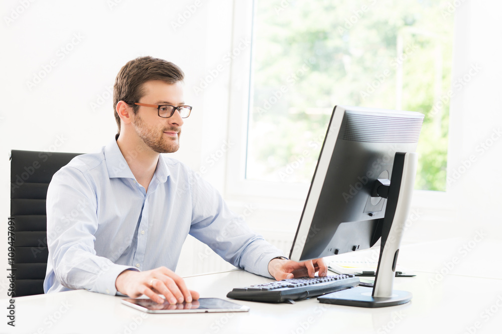 Young and confident businessman working in a modern office Young and confident businessman working in a modern office