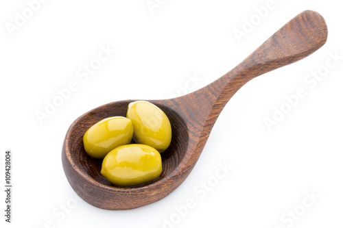 Olives on the spoon leaves isolated on white.