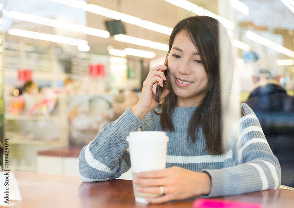 Young woman talking on the phone in coffee shop Young woman talking on the phone in coffee shop
