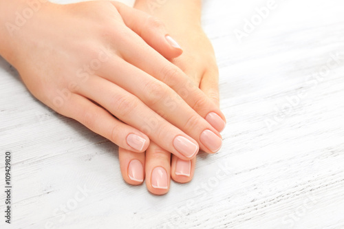 Woman hands with beautiful manicure on wooden background