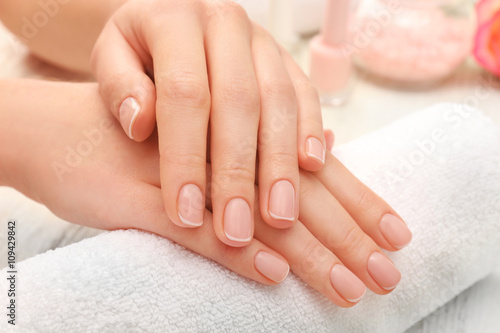 Woman hands with beautiful manicure on towel, close up
