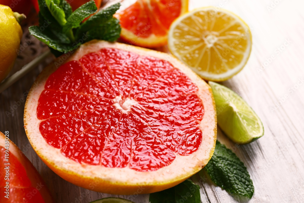 Pieces of different citrus fruit on light wooden table Pieces of different citrus fruit on light wooden table