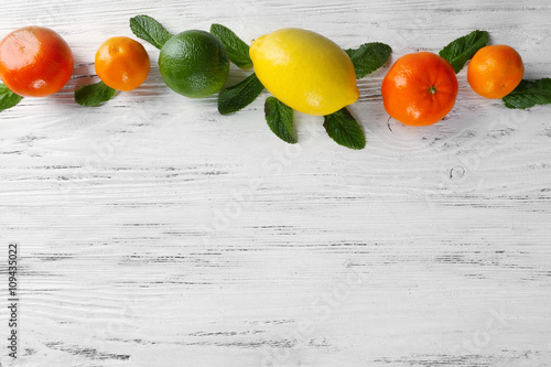 Set of different citrus fruit on light wooden background