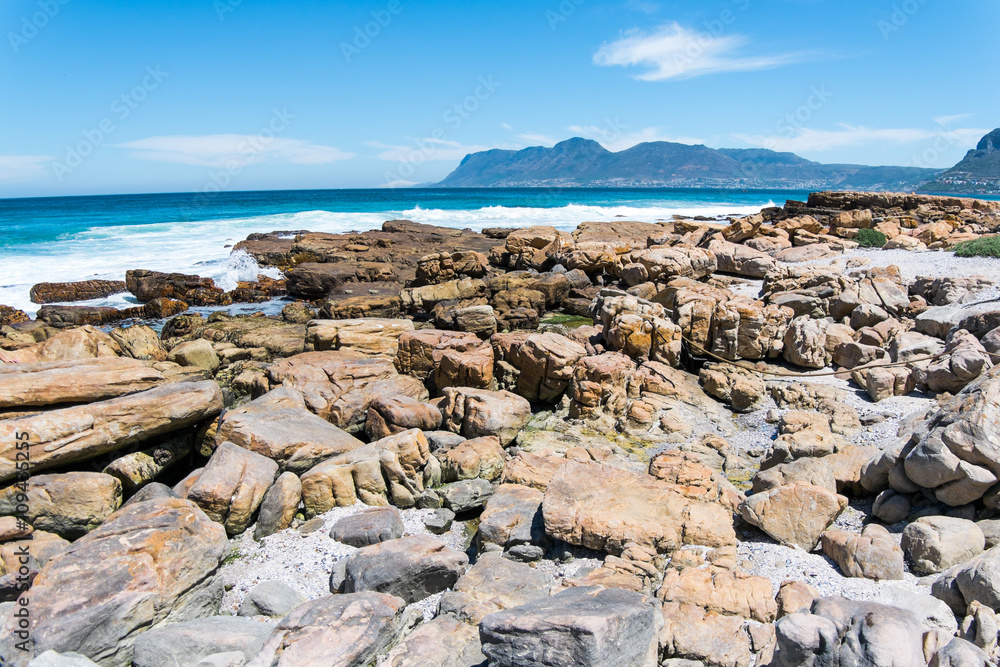 Rock beach with blue sky and mountain background in Cape Town, South Africa