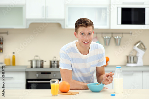 Handsome man having breakfa...