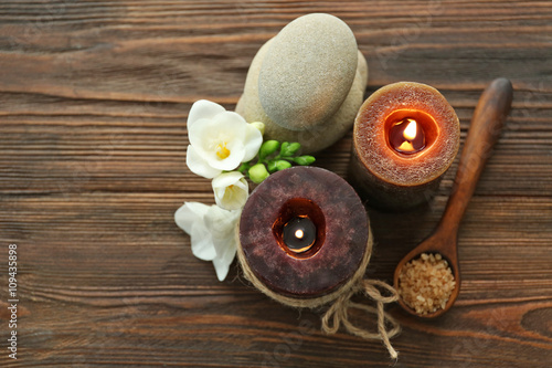 Spa set with sea salt, flowers and candles on wooden background