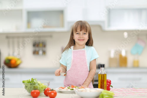 Little girl with a plate of vegetable salad.