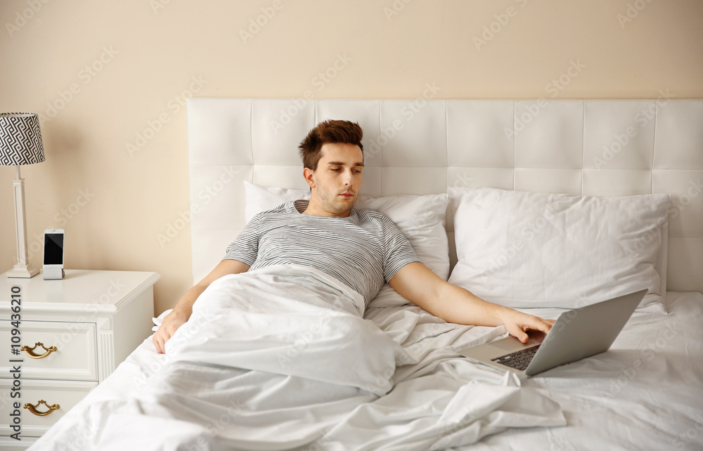 Man lying in bed with his laptop Man lying in bed with his laptop