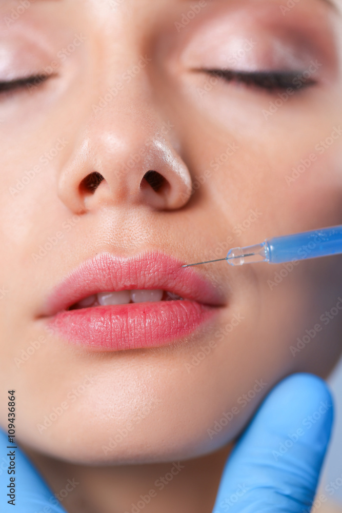 Cosmetic injection on the pretty woman face. Isolated on gray background Cosmetic injection on the pretty woman face. Isolated on gray background