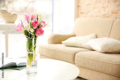 Beautiful fresh tulips and irises on wooden table, indoors