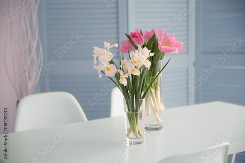 Beautiful tulips and irises on dinning table , indoors © Africa Studio