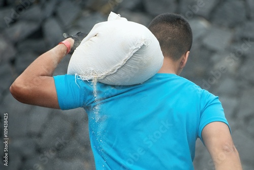 Mud race runners,young man carrying tear sandbag photo