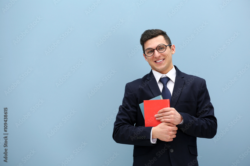 Attractive young man in a suit against light blue wall Attractive young man in a suit against light blue wall