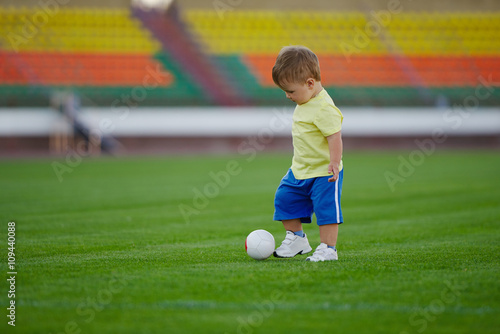 little funny boy on football stadium