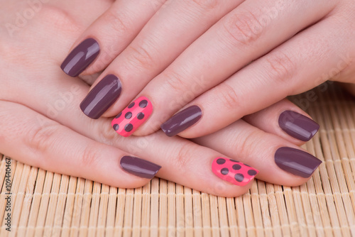 Manicure - Beauty treatment photo of nice manicured woman fingernails. Very nice feminine nail art with nice pink and purple nail polish.