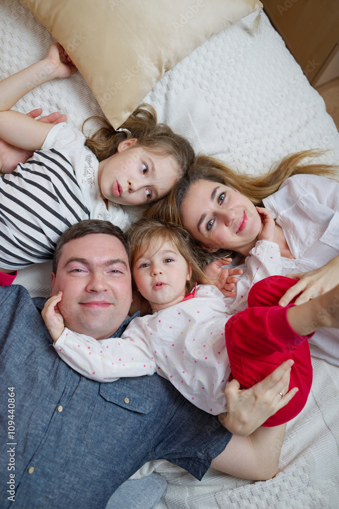 happy young family lying in bed